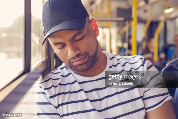 male passenger napping in public bus - man sleeping with cap stock pictures, royalty-free photos & images