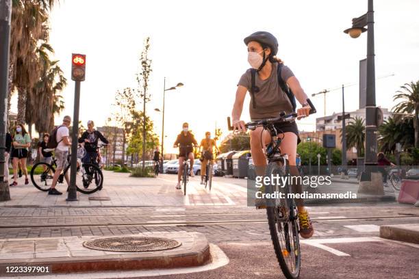 people doing sport and walking during the coronavirus pandemic on the paseo marítimo in valencia, spain - cycling stock pictures, royalty-free photos & images