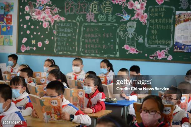Students wearing face masks have a class at a primary school on May 7, 2020 in Huhhot, Inner Mongolia Autonomous Region of China. A part of primary...