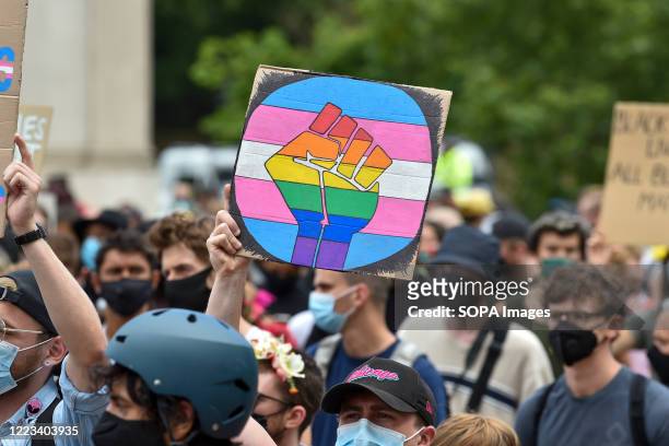 Placard with a fist in pride rainbow colours at the Black Trans Lives Matters' march in London. Thousands of activists have marched through London in...