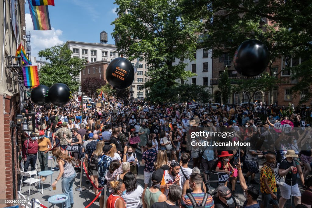 Gay Rights Rally People wearing masks walk past the Stonewall Inn during the the Queer ...