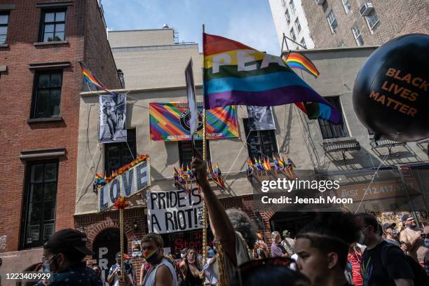Gay Rights Rally People wearing masks walk past the Stonewall Inn during the the Queer ...