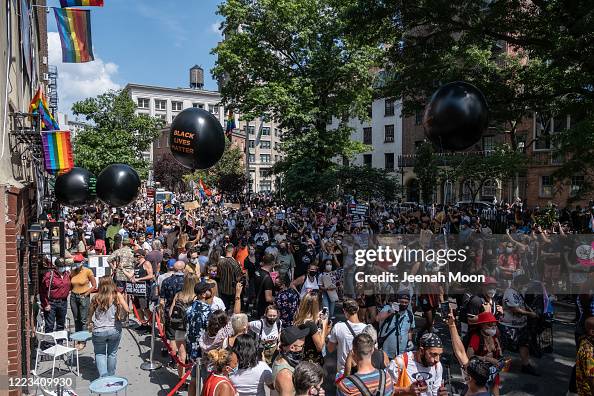 Gay Rights Rally People wearing masks walk past the Stonewall Inn during the the Queer ...