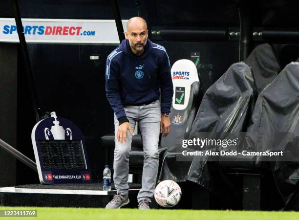 Manchester City manager Josep Guardiola stops a ball during the FA Cup Quarter Final match between Newcastle United and Manchester City at St. James...
