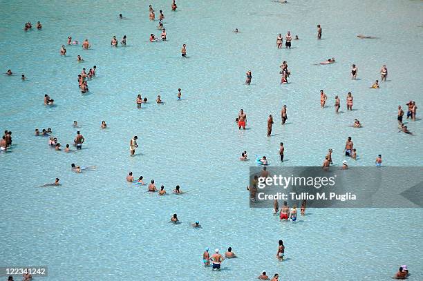 People bathe near the island of Isola dei Conigli on August 23, 2011 in Lampedusa, Italy. Isola dei Conigli is one of the last remaining egg-laying...