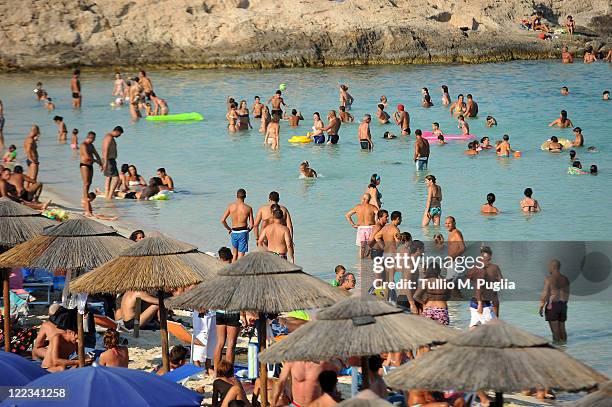 Sun seekers enjoy Guitgia Beach on August 23, 2011 in Lampedusa, Italy. As Italy's southernmost island, Lampedusa lies between Malta and Tunisia and...