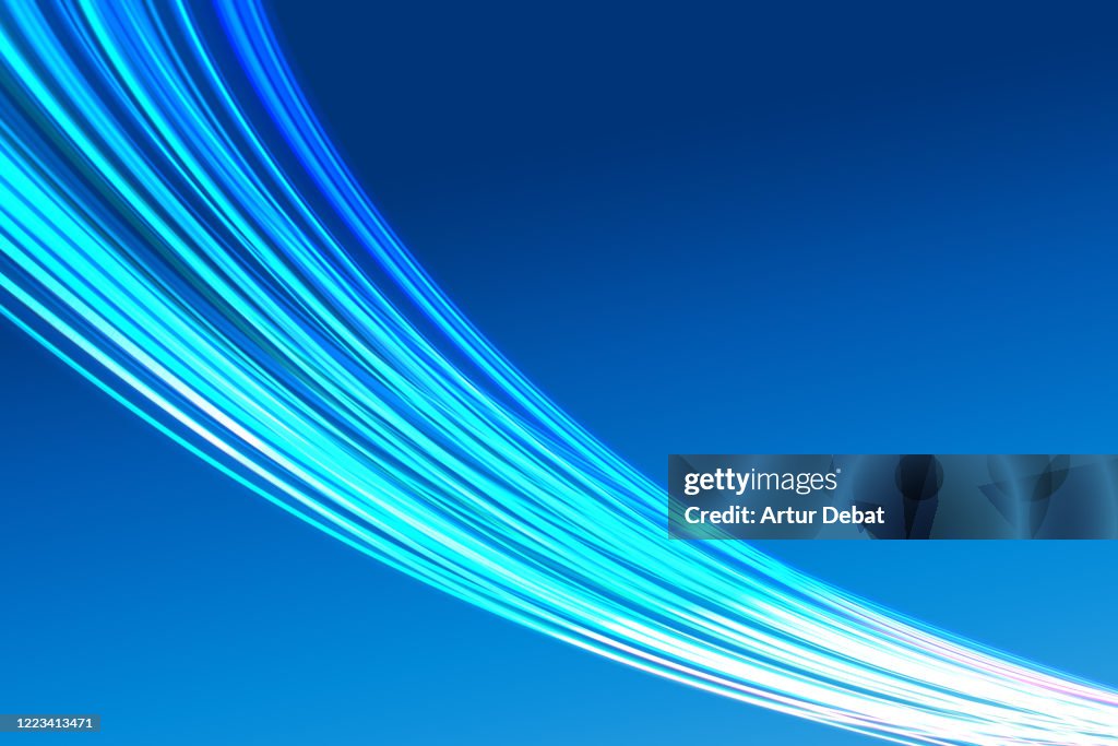 Abstract picture of bright light trails crossing the blue sky with fast motion.