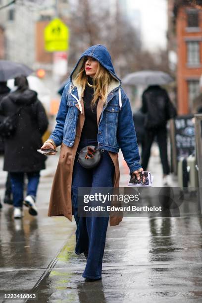 Guest wears a blue denim jacket with hood and white wool inner lining, a brown trench coat, a black leather belt bag with attached sunglasses, blue...