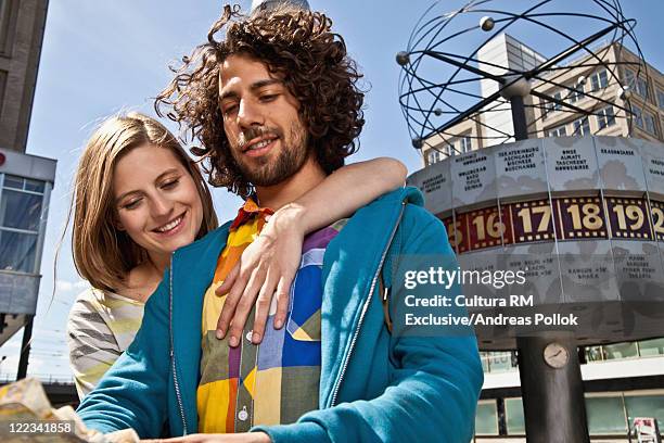 couple reading map at alexanderplatz - andreas pollok stock-fotos und bilder