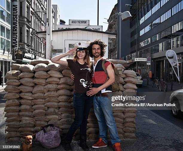 couple smiling at checkpoint charlie - checkpoint charlie stock-fotos und bilder