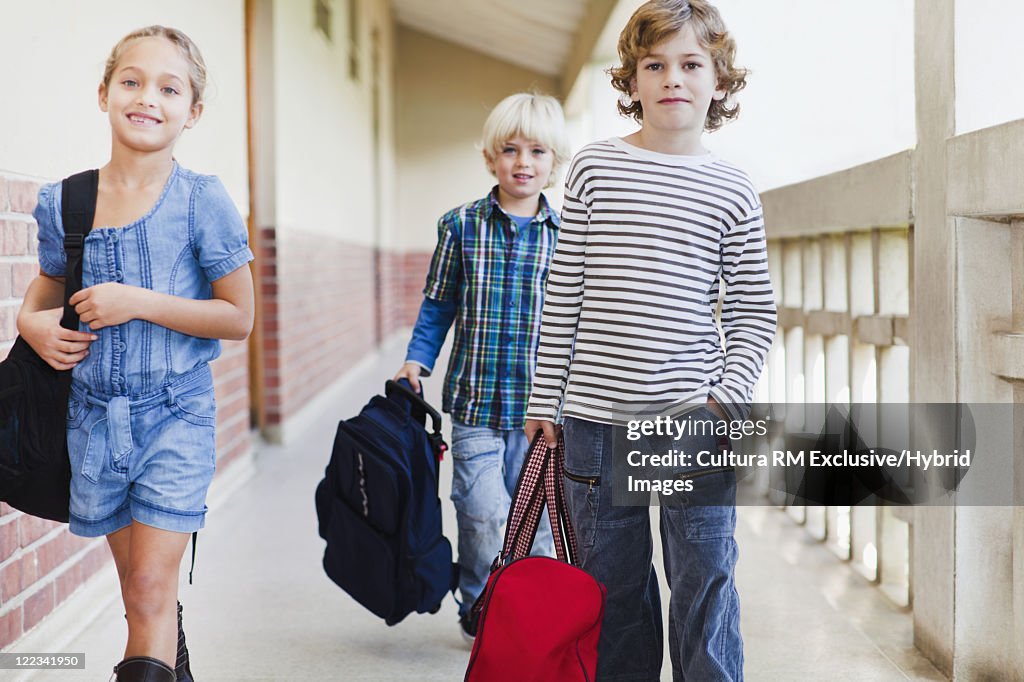 Children carrying backpacks at school