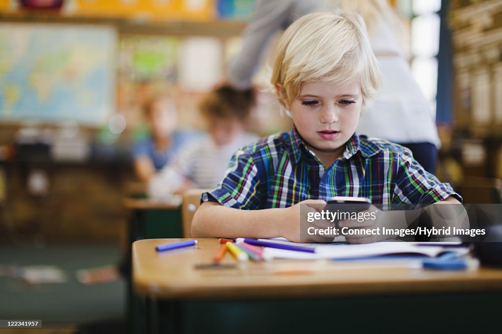 Boy using calculator in class