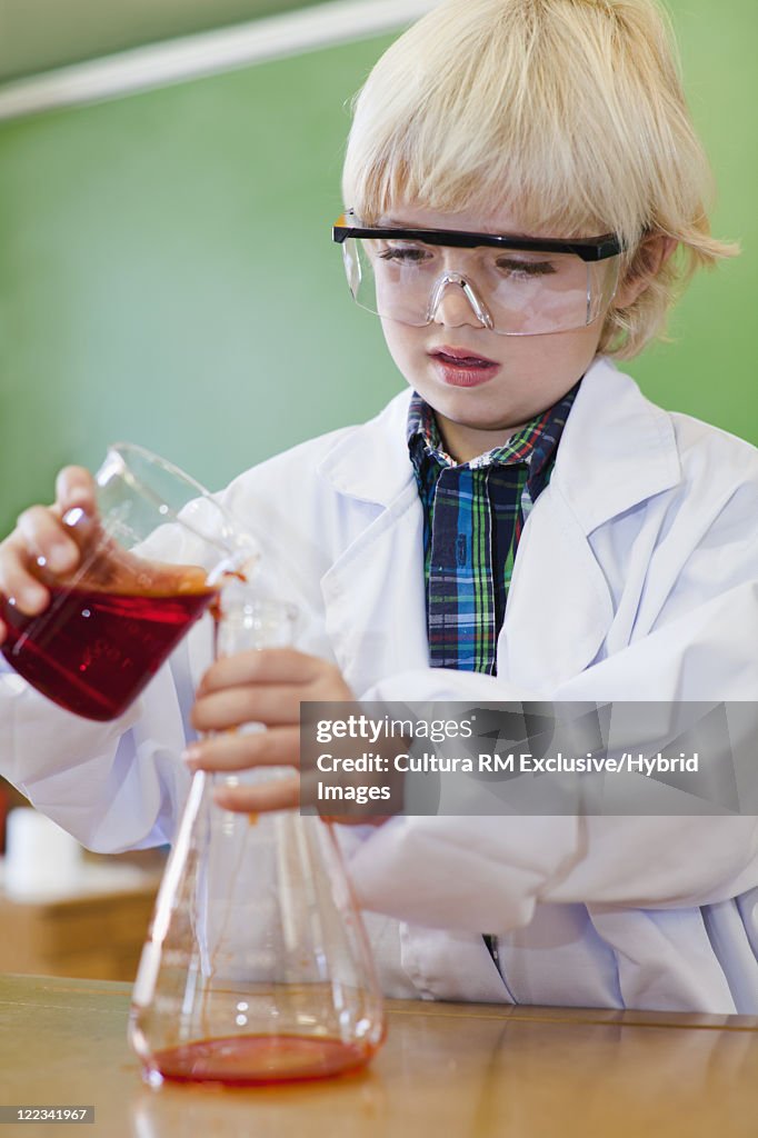 Boy pouring liquid into beaker