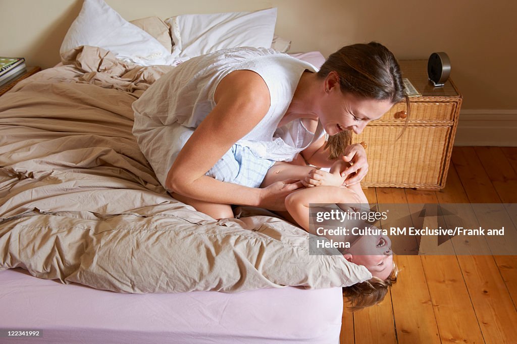 Mother and son playing on bed