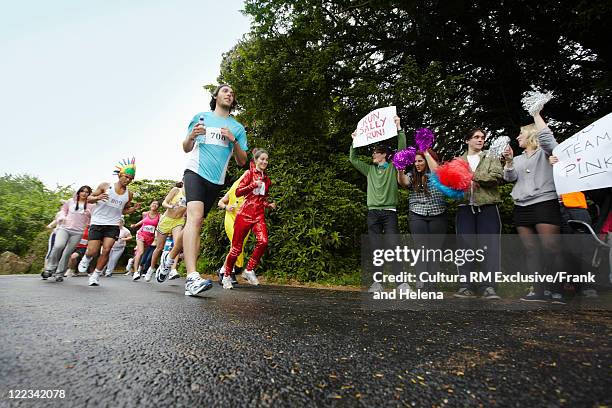 runners racing in marathon - marathon zuschauer stock-fotos und bilder