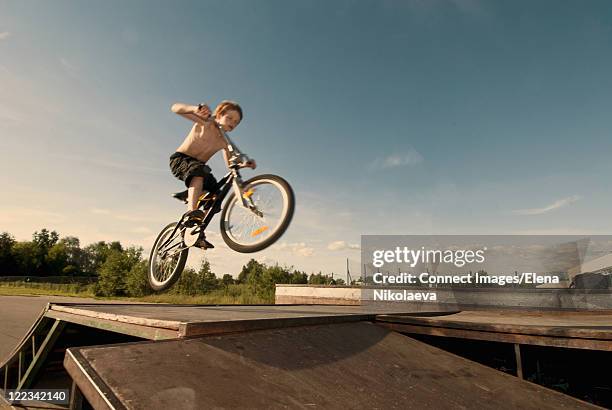 boy doing tricks on bike - motocross stock-fotos und bilder