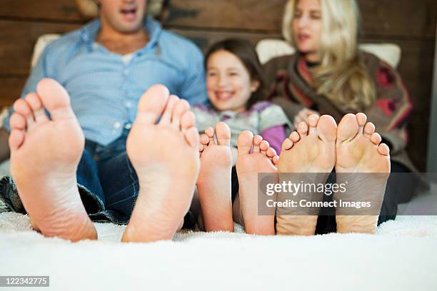 family on bed with barefeet - voetzool stockfoto's en -beelden