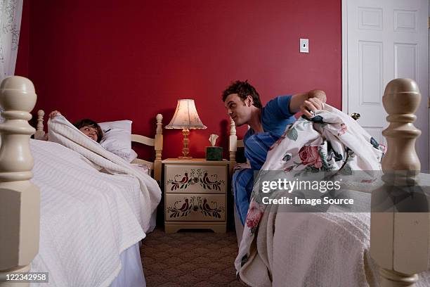 young man getting out of bed to see young woman - eenpersoonsbed stockfoto's en -beelden