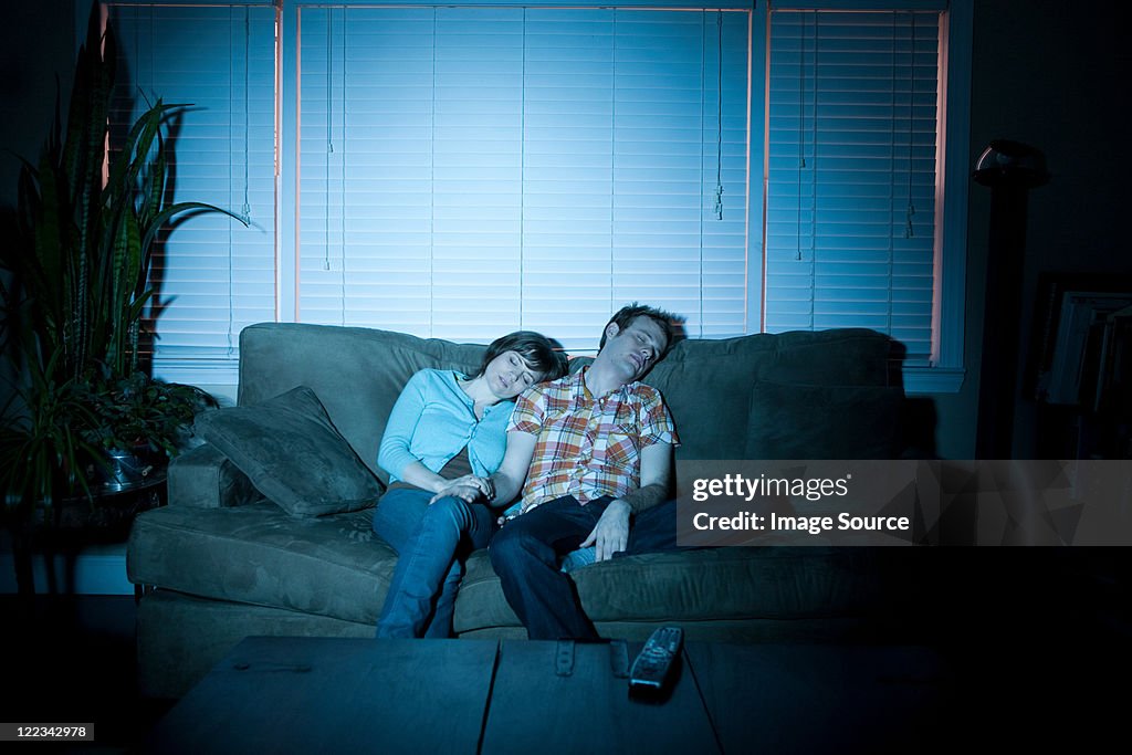 Young couple fallen asleep in front of tv