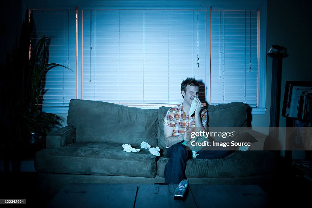 Young man watching tv, crying