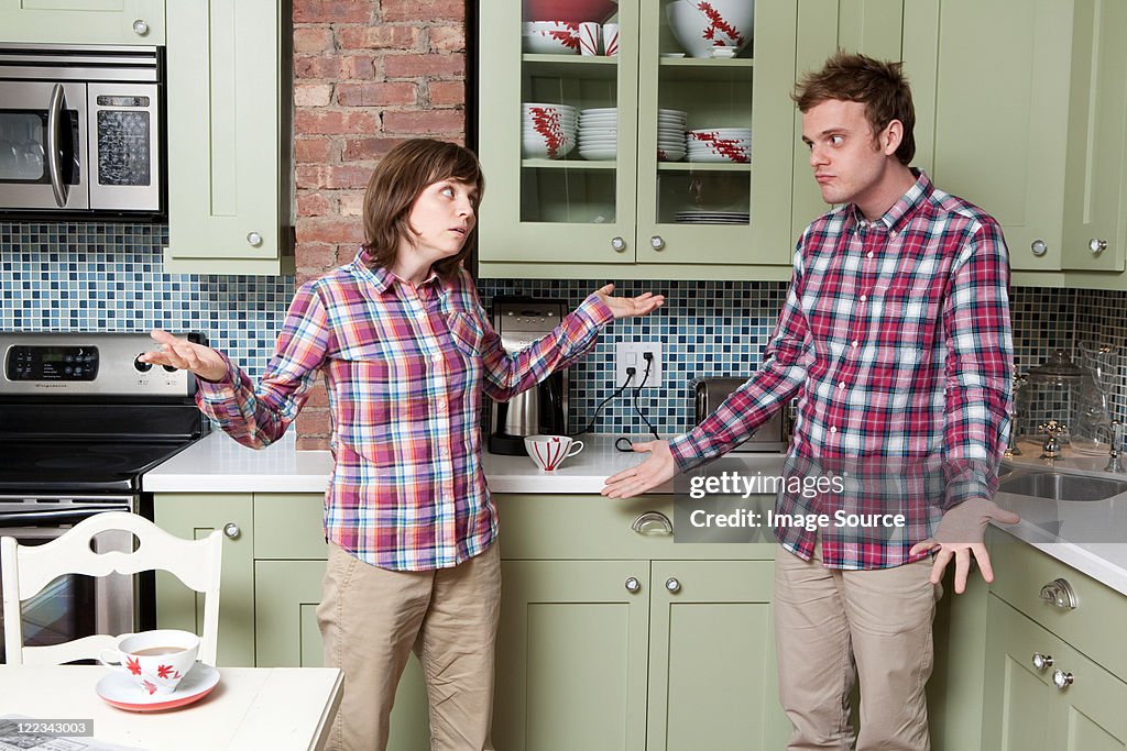 Young couple shrugging in kitchen
