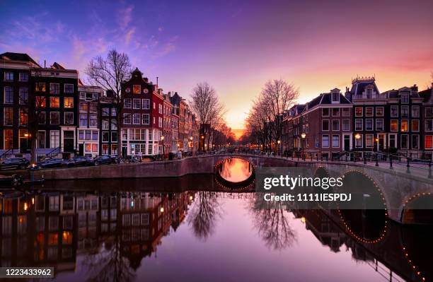 amsterdamse grachten en typische grachtenpanden in de schemering - amsterdam canals stockfoto's en -beelden