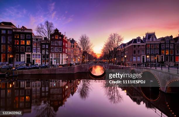 amsterdam canals and typical canal houses at dusk - amsterdam stock pictures, royalty-free photos & images