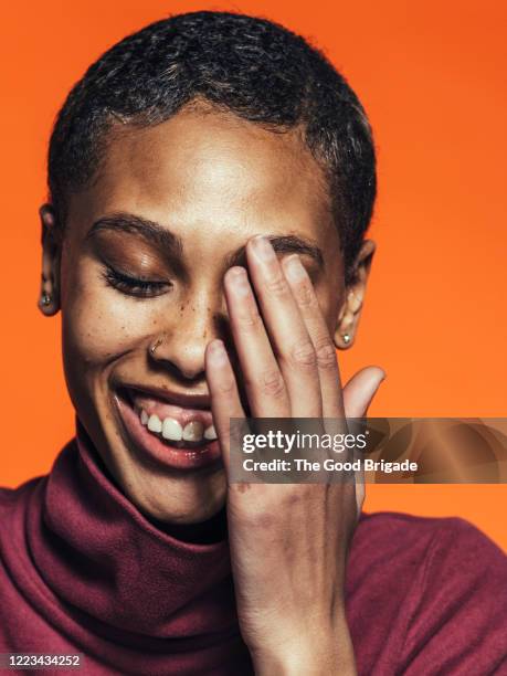 portrait of young woman laughing - hands covering eyes 個照片及圖片檔