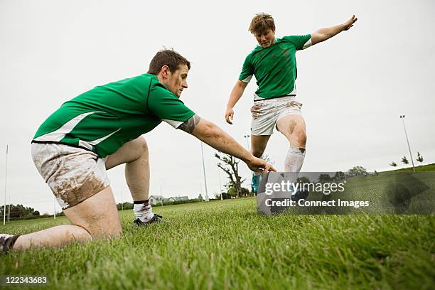 rugby player kicking ball - ireland rugby photos et images de collection