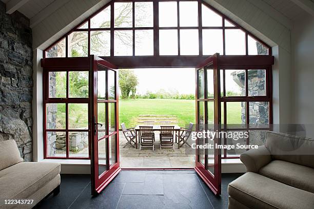 room with doors open onto patio - french doors stock pictures, royalty-free photos & images