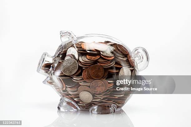 transparent piggy bank full of coins - zakgeld stockfoto's en -beelden