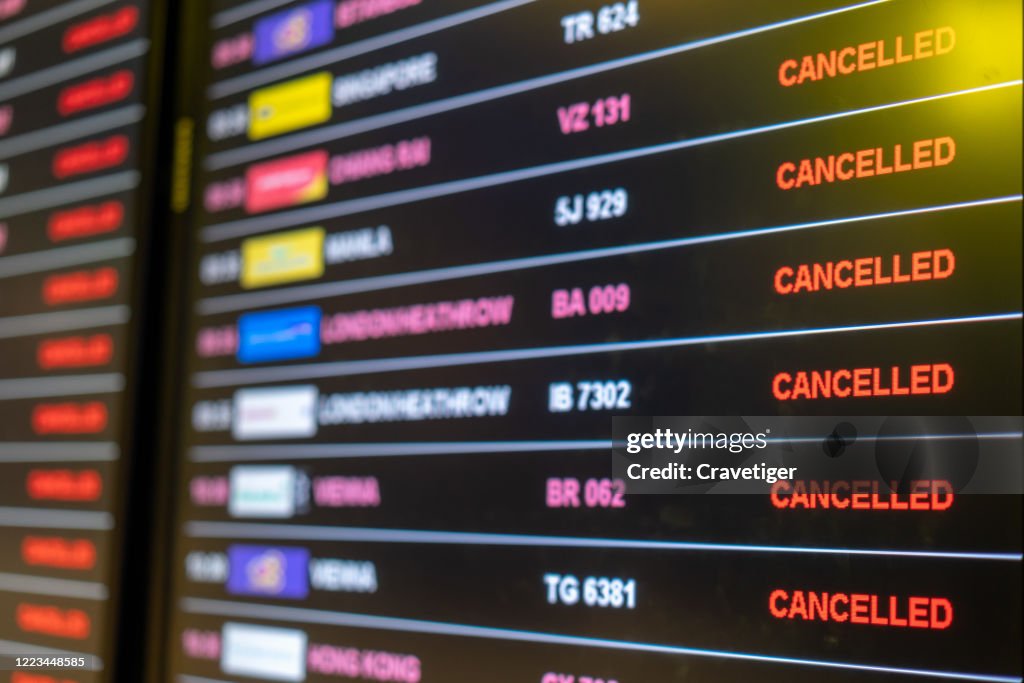 Airport departures board showing a number of flights boarding, or on their cancelled .