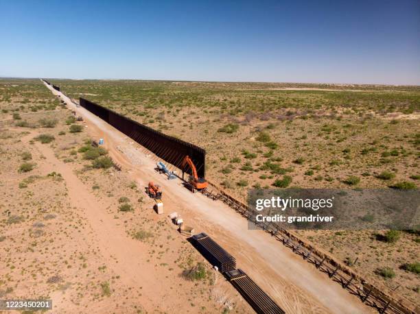 aerial view of the work site where the international border wall is being constructed - border fence stock pictures, royalty-free photos & images