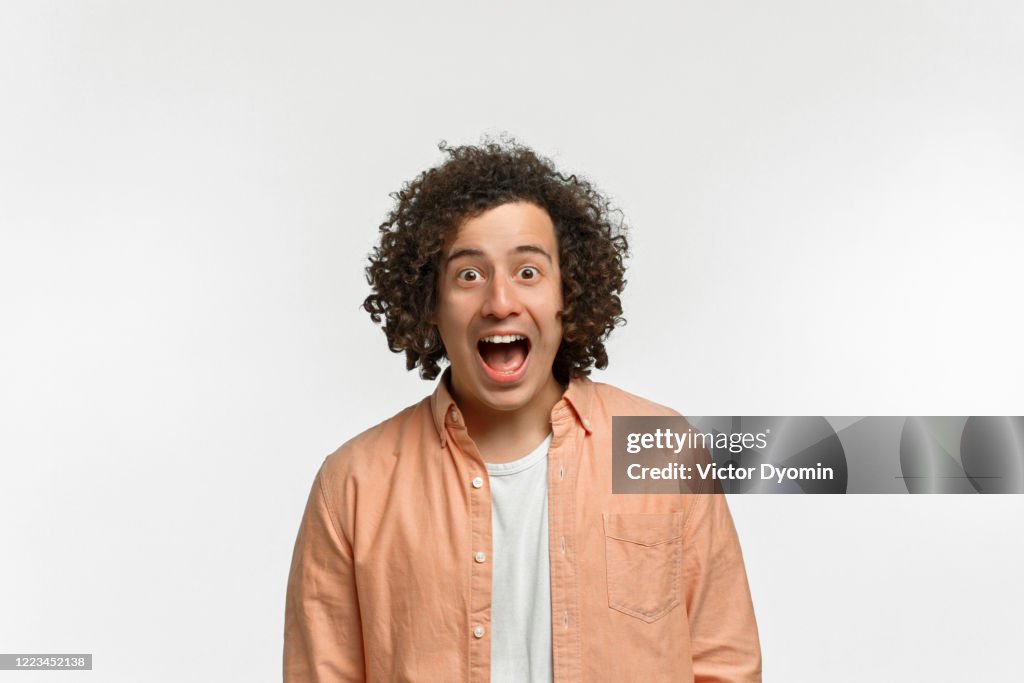 Emotional portrait of a curly guy with brown hair