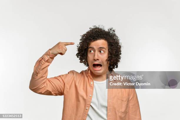 emotional portrait of a curly guy with brown hair - wally stock pictures, royalty-free photos & images