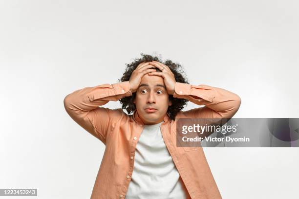 emotional portrait of a curly guy with brown hair - crisi foto e immagini stock