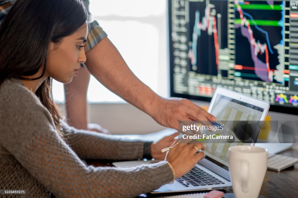 Young business woman day trading from her dining room table