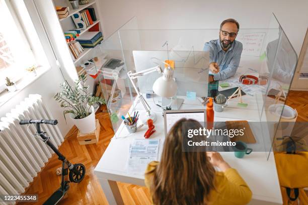 business colleagues discussing plan on glass wall partition - screen partition stock pictures, royalty-free photos & images