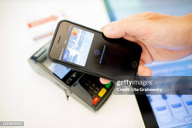 In this photo illustration a man pays with touch ID off his cellphone on June 12, 2020 in Bonn, Germany.