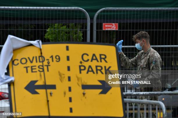 Member of Britain's armed forces directs a member of the public at a mobile COVID-19 testing centre, at Victoria Park in Leicester, central England,...