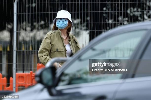 Member of the public arrives to deposit a used self-test kit to be processed at a mobile COVID-19 testing centre, at Victoria Park in Leicester,...