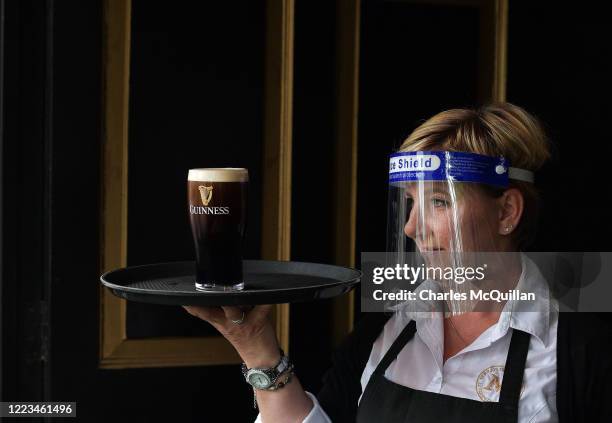 Barmaid waits for a pint of Guinness to settle before serving a customer at Murrays pub on Grafton street on June 29, 2020 in Dublin, Ireland....