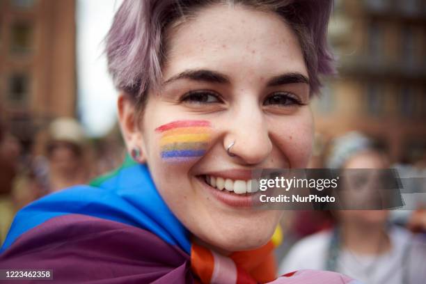 Young woman has painted the rainbow clors on her cheek. Due to the Covid-19 pandemic, the annual Pride March became a gathering as marches are...