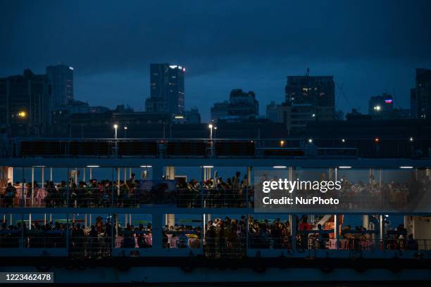 Commuters take a ferry to cross Yangon river during a heavy rainfall in Yangon on June 29, 2020.