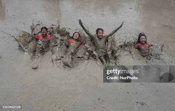 Children play in the mud at the paddy field during the National Paddy Day also called Asar Pandra on the outskirts of Kathmandu, Nepal, June 29,...