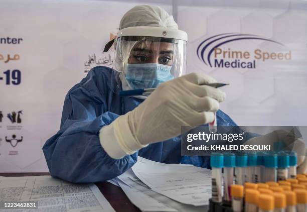 An Egyptian health worker checks samples at a drive-through coronavirus-testing center at the Ain Shams University in Cairo on June 29, 2020. - Egypt...