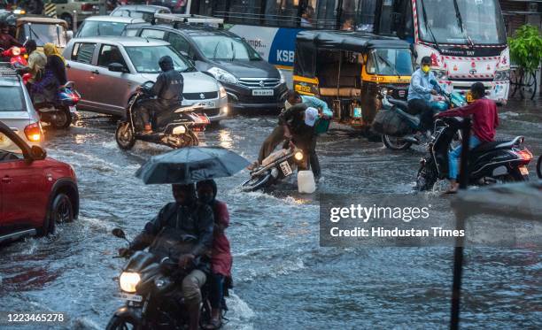 People commute on a rainy evening from waterlogged area at Narpatgiri Chowk, Mangalwar Peth on June 29, 2020 in Pune, India.