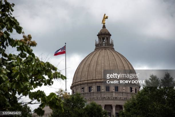 The state flag flies over the Mississippi State Capitol building in Jackson, Mississippi on June 29, 2020. - Lawmakers in Mississippi voted to remove...