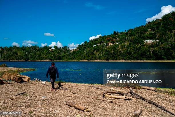 Fisherman walks on the banks of the unusually low Carraizo reservoir in Trujillo Alto, Puerto Rico on June 29, 2020. - The drought in Puerto Rico...