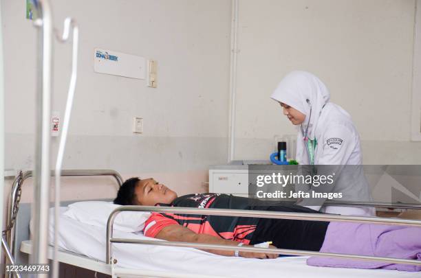 Nurse checks Aria Permana's arm before surgery in the intensive care unit room, Hasan Sadikin Hospital, Bandung, West Java, Indonesia. ONCE known as...